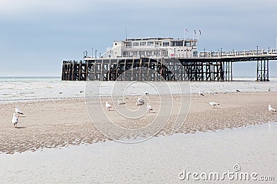 Worthing beach and pier in a cloudy day, low tide, England.