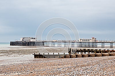 Worthing beach and pier in a cloudy day, low tide, England.