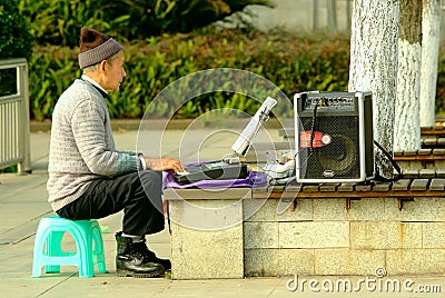 Yaan China-An old man is playing electronic organ