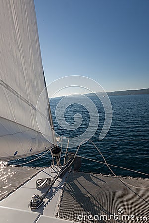 Yacht on the open ocean. Island on the horizon.