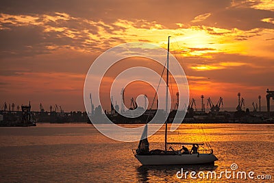 Yacht sails in Varna harbor at the sunset