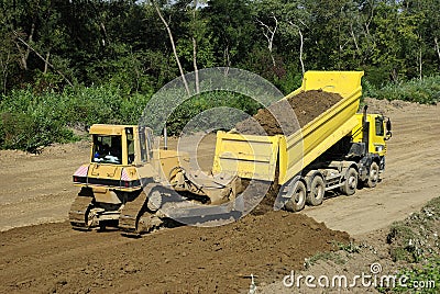 Yellow bulldozer and dump truck