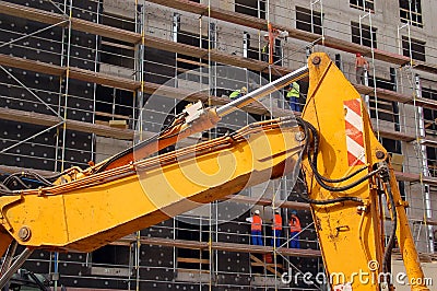 Yellow digger and construction workers