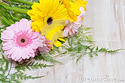 Yellow and pink flowers on wooden background