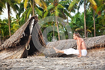 Yoga angusthasana pose on the beach