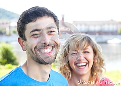 Youing couple in colorful shirts laughing loud