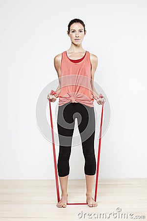 Young active woman using elastic band for training