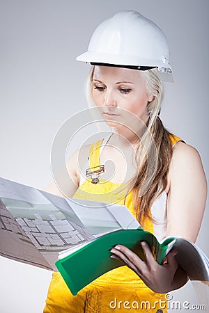 Young architect woman construction worker, blueprints plan