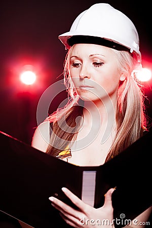 Young architect woman construction worker reading blueprints