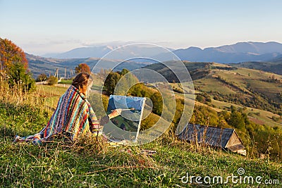 Young artist painting an autumn landscape