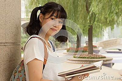 Young Asian girl studying hard in the park