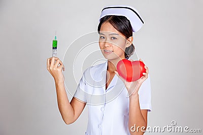 Young Asian nurse hold syringe and red heart