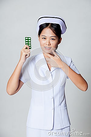 Young Asian nurse point to pack of tablet