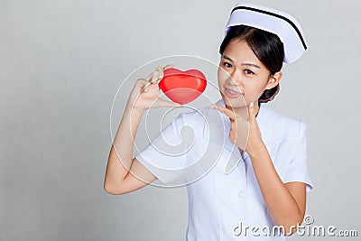 Young Asian nurse point to red heart