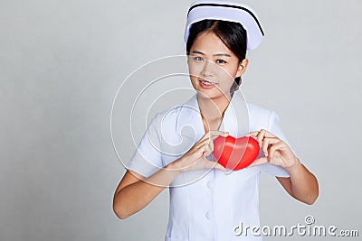 Young Asian nurse show red heart on her chest