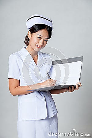 Young Asian nurse smile working on a report