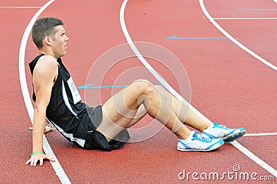 Young athlete sitting on the ground after running race