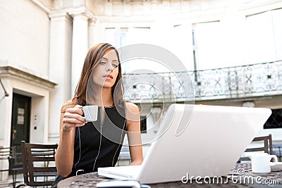 Businesswoman with laptop in cafe.