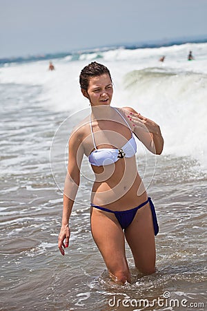 Young attractive girl bathes at the ocean