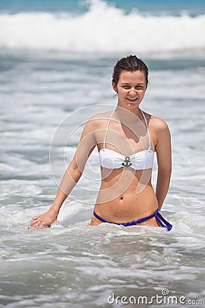 Young attractive girl bathes at the ocean
