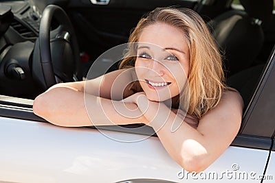 Young attractive happy woman sitting in car