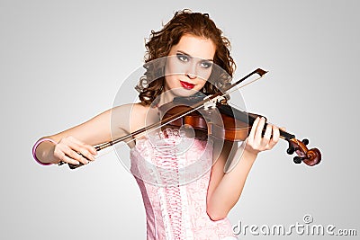 Young attractive woman in pink corset on a violin