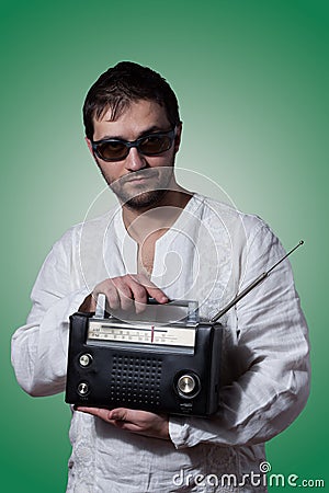 Young bearded man holding a vintage radio