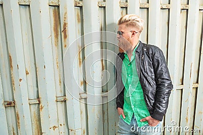 Young bearded man poses at iron fence