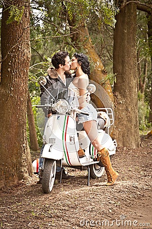 Young beautiful couple with scooter along dirt road