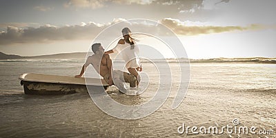 Young beautiful couple spending afternoon on beach with old bath tub