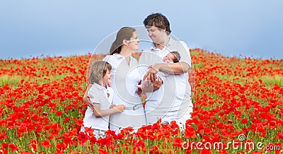 Young beautiful family in a red flower field