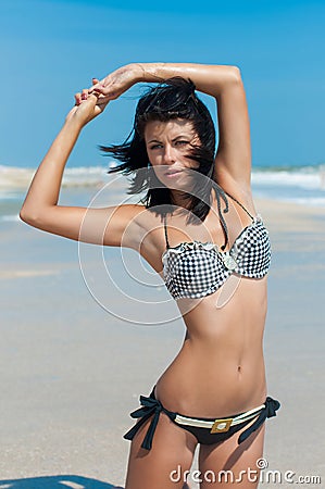 Young beautiful girl in a bikini on a beach