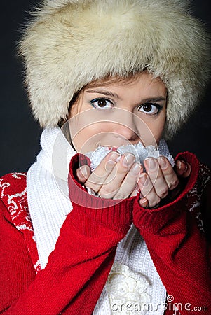 The young beautiful girl in a fur cap has control