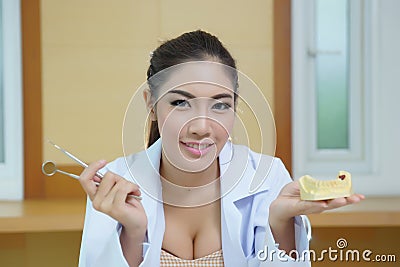 Young beautiful woman dentist holding denture cast model