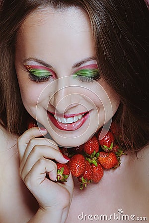 Young beautiful woman enjoying strawberries and smiling