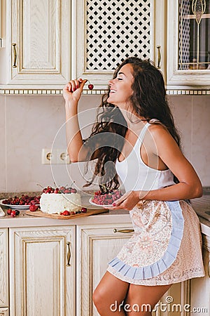 Young beautiful woman making cake at the kitchen