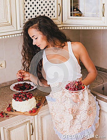 Young beautiful woman making cake at the kitchen