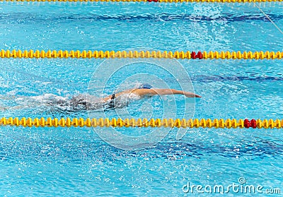 Young beautiful woman swims in pool