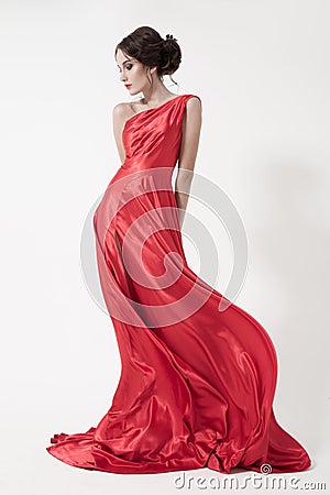 Young beauty woman in fluttering red dress. White background.