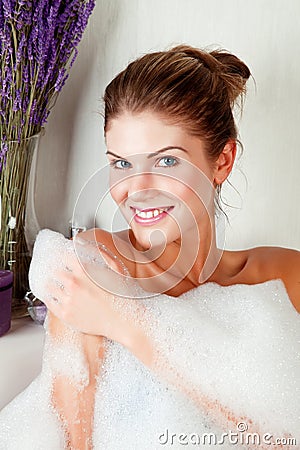 Young beauty woman in the full of foam bathtub