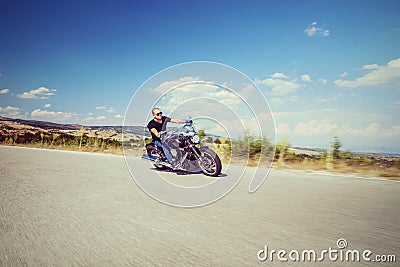 Young biker riding a motorcycle on an open road