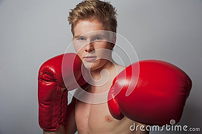 Young blond man with boxing gloves