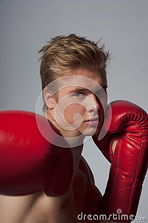 Young blond man with boxing gloves