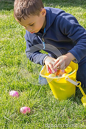 Young Boy Bends Over his Bucket to Collect Easter