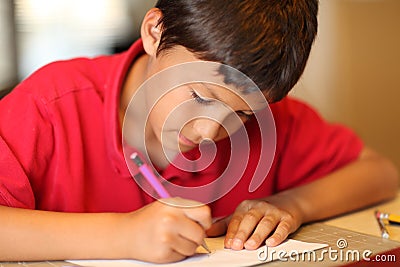 Young boy drawing for homework