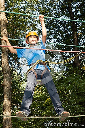 Boy with equipment climber moves on ropes