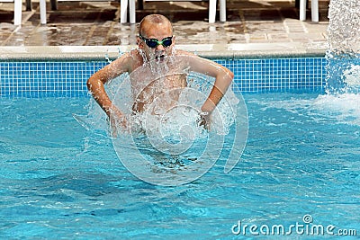 Young boy jumping in the pool on vacation