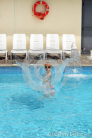 Young boy kid jumping in the pool