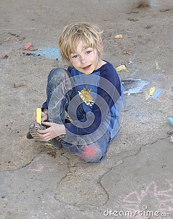 Young boy playing with sidewalk chalk