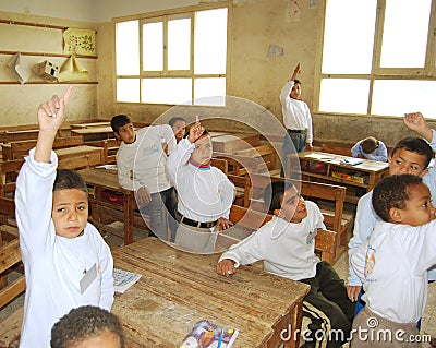 Young boys raising hands for answer question